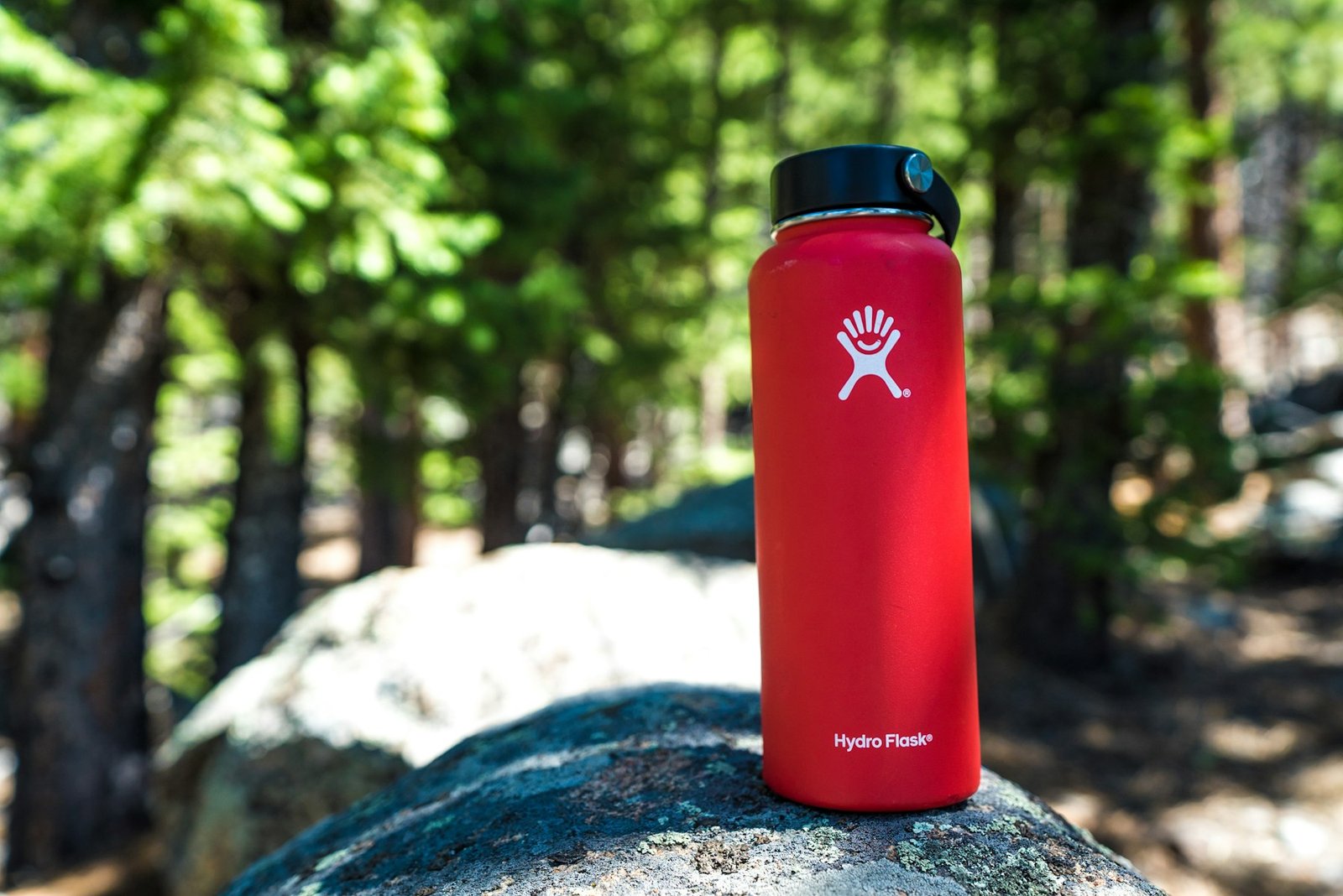 Insulated water bottle standing on a rock outdoors
